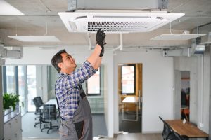 A technician fixing a commercial HVAC system