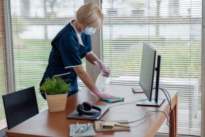 a cleaning lady wiping dust in an office