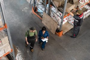 Workers going through a warehouse maintenance checklist