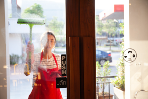 Employee cleaning a door in retail space