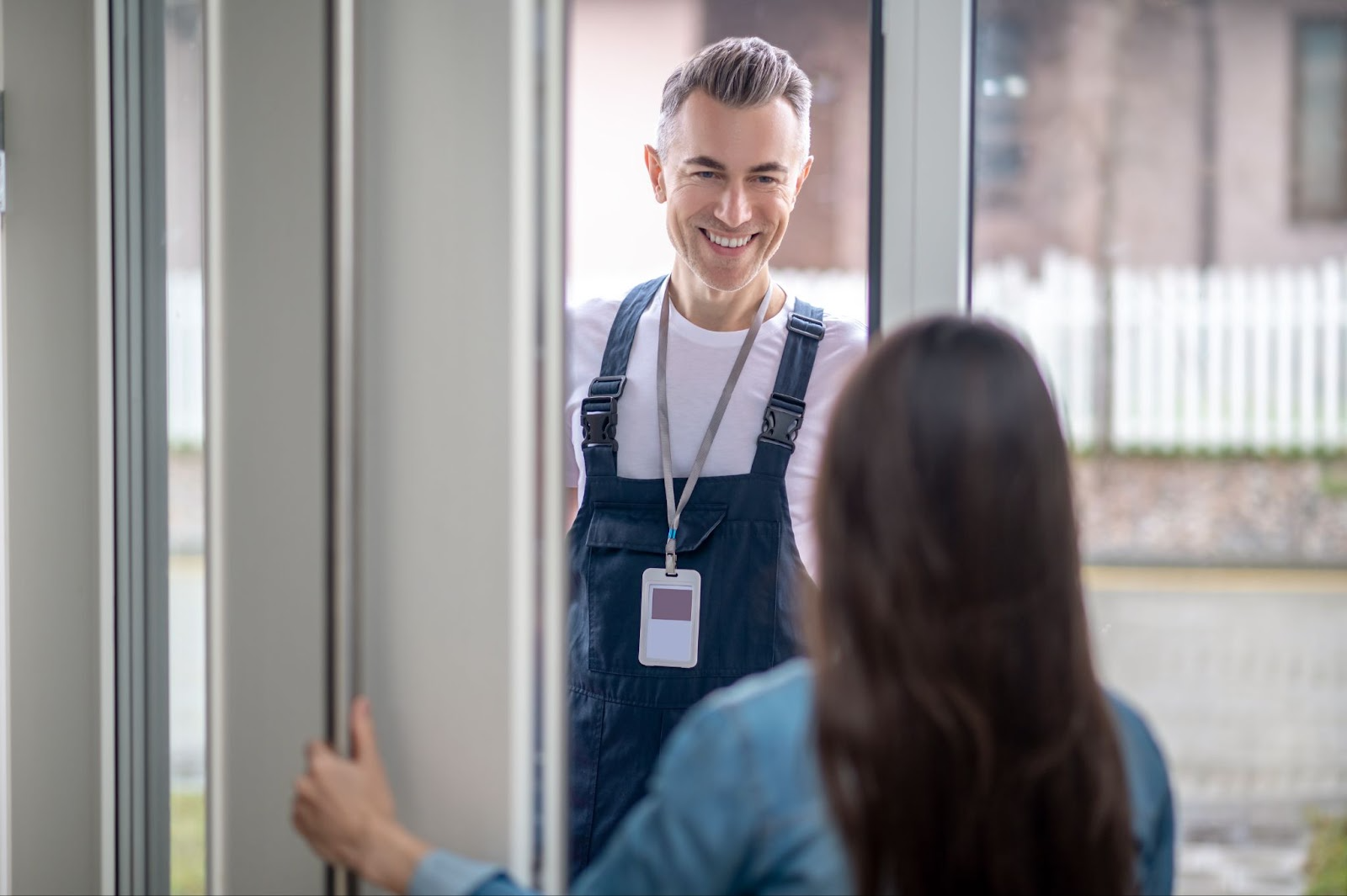 repair man talking to a women in front of a door
